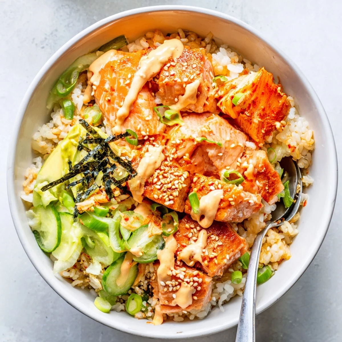 Vibrant crispy salmon rice bowl with fluffy rice, spicy mayo, and colorful garnishes.  