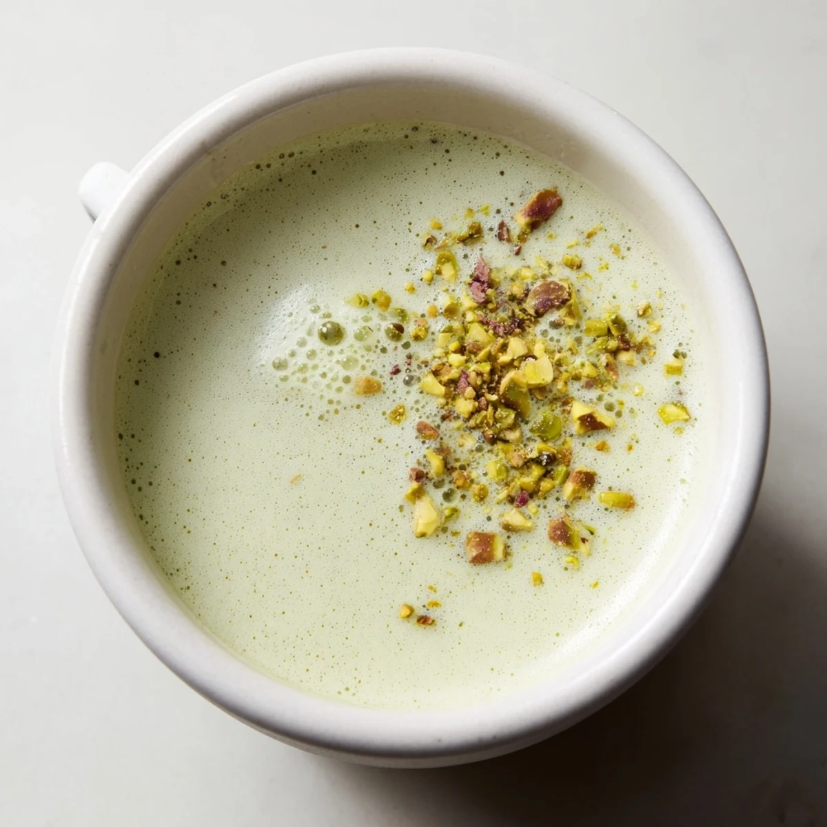 Delicious pistachio milk latte garnished with nuts, a unique twist on coffee.