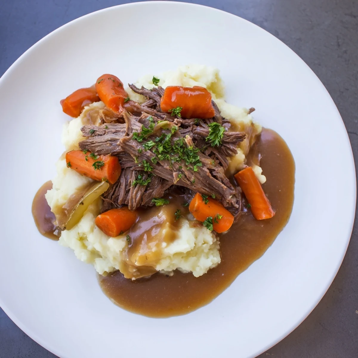 Hearty slow cooker pot roast with tender vegetables and creamy mashed potatoes makes a comforting dinner.