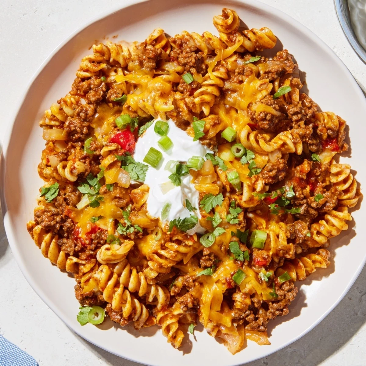 A steaming skillet of Cheesy Taco Pasta showcasing melted cheese and savory ground beef.