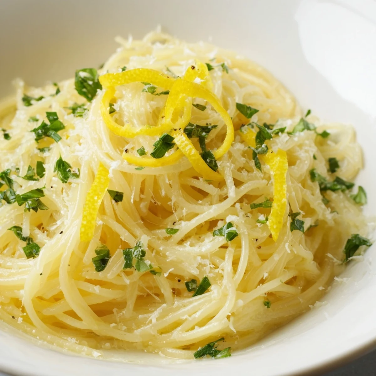 Steaming bowlful of Lemon Capellini with fresh herbs, a bright, citrusy Italian pasta delight.