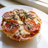 Golden-topped mini pepperoni pizza bagels, a perfect snack with bubbling cheese and red sauce.