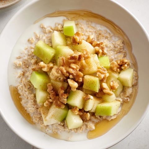 Steaming Apple Pie Oatmeal Bowl, showcasing caramelized apples atop creamy cinnamon-infused oats.
