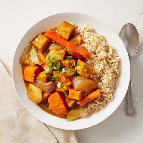 A vibrant bowl of Japanese Curry Pumpkin Twist served over fluffy steamed rice.  