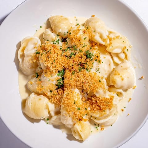 A close-up of creamy Truffle Macaroni & Cheese, rich with melted cheese and pasta.
