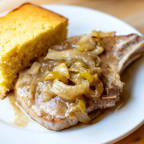 Comforting Southern meal: tender smothered pork chops and sweet, crumbly cornbread, perfect for dinner.