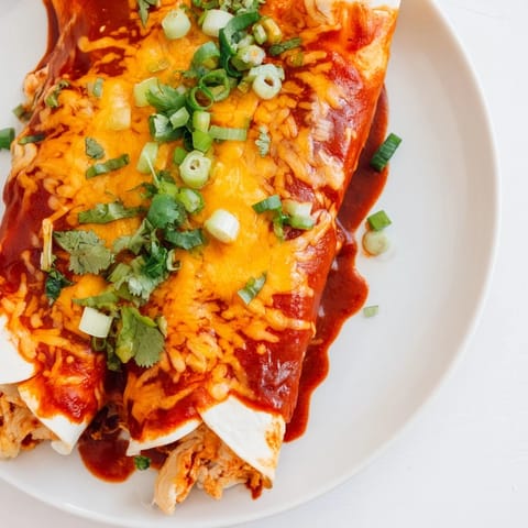 Golden brown Cheesy Bean Enchiladas are ready to serve, with a bubbly cheese topping and vibrant cilantro.