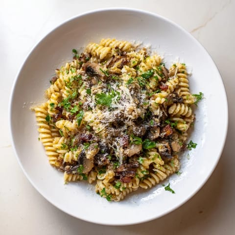 Golden-brown bacon and earthy mushrooms in this flavorful fusilli recipe with onions.