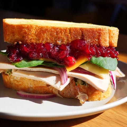 Golden-grilled Budget Christmas Sandwich on Brioche, a delicious holiday sandwich with savory turkey and cranberry filling.