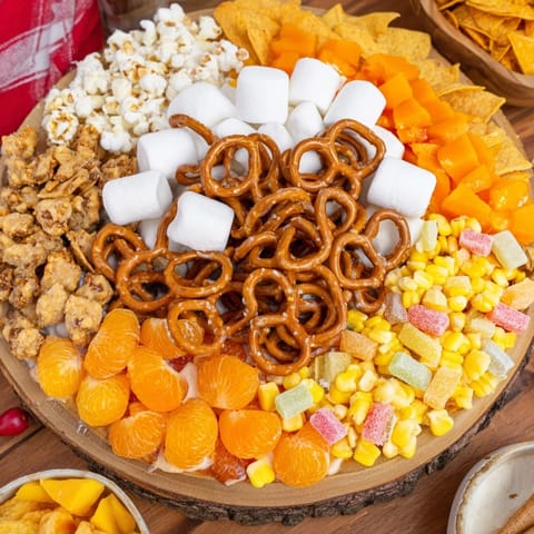 A close-up of a festive candy corn spooky board overflowing with tempting Halloween treats.