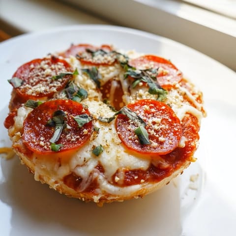Golden-topped mini pepperoni pizza bagels, a perfect snack with bubbling cheese and red sauce.