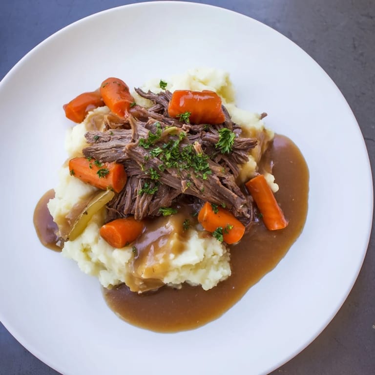 Hearty slow cooker pot roast with tender vegetables and creamy mashed potatoes makes a comforting dinner.
