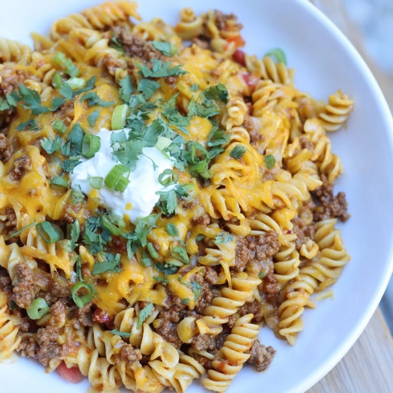 Creamy Cheesy Taco Pasta with a vibrant mix of pasta shapes and colorful diced tomatoes.