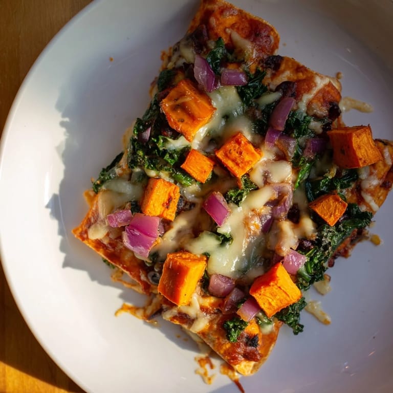 Vibrant one-pan sweet potato, black bean & kale enchiladas ready to be garnished and enjoyed.