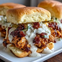 Crockpot Mississippi Chicken Sliders with Coleslaw: Tender shredded chicken slow-cooked in rich, savory spices, piled high on soft slider buns with tangy coleslaw for a crowd-pleasing bite.